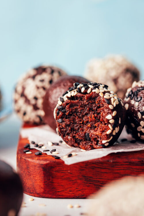 Close up shot of a partially eaten chocolate tahini truffle to show the inner texture