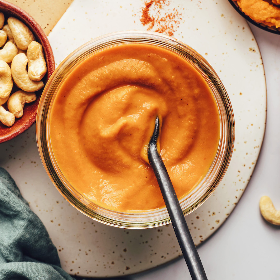 Top down shot of a jar of creamy homemade pumpkin enchilada sauce