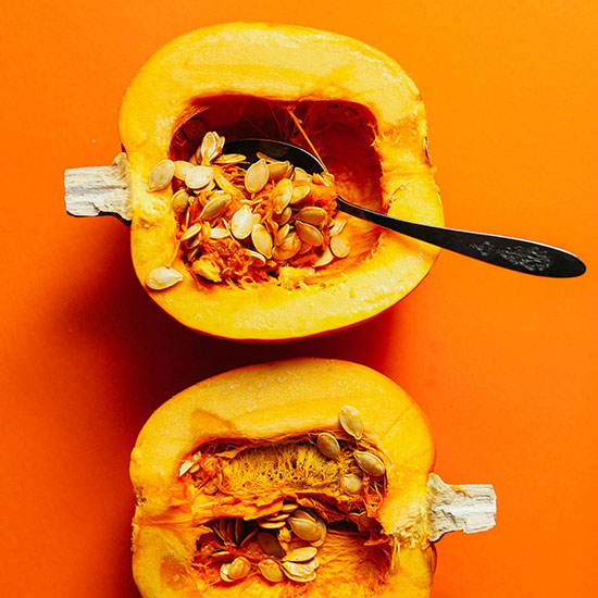 Spoon resting in the hollow portion of a halved pumpkin