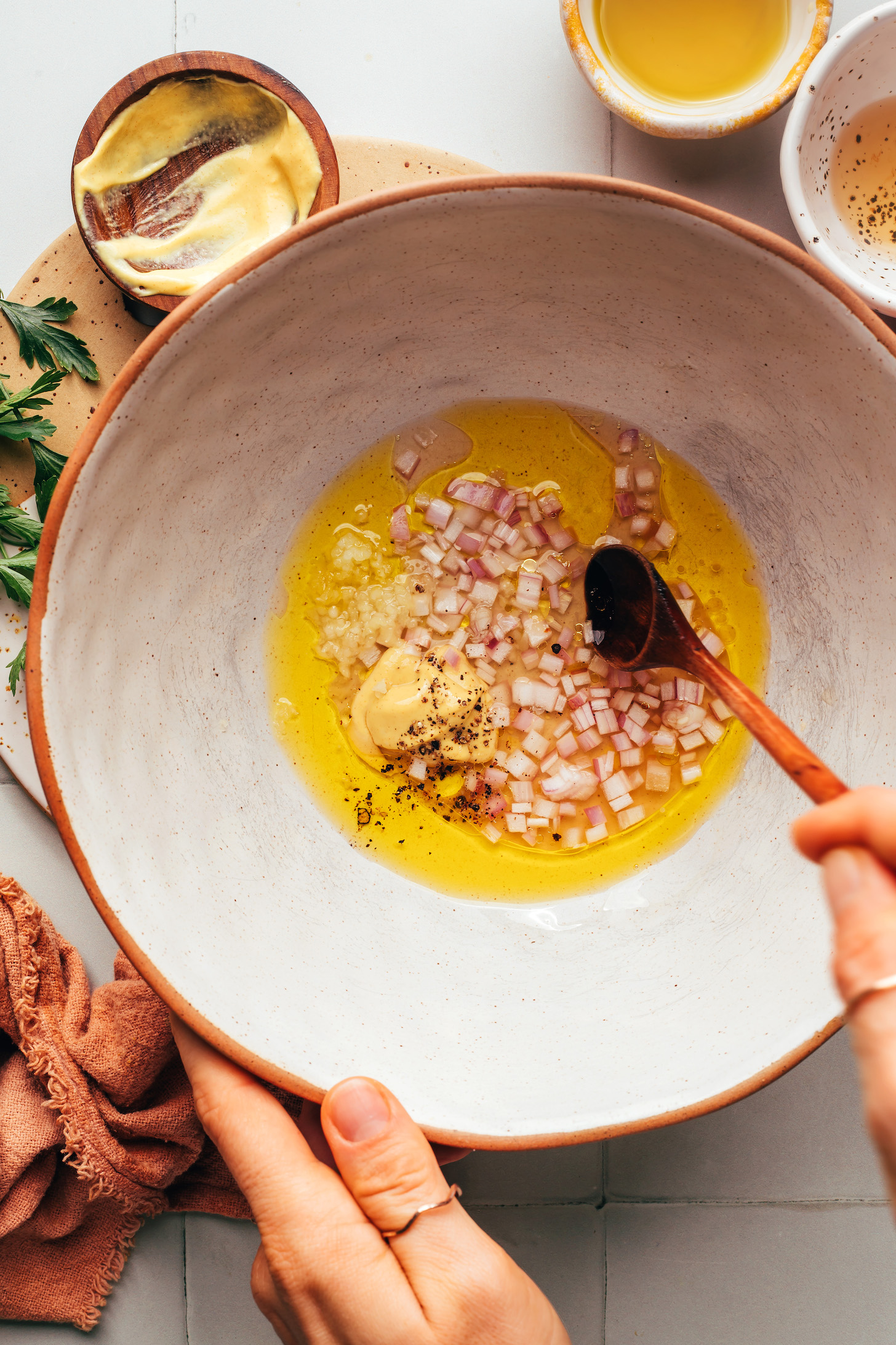 Bowl with olive oil, apple cider vinegar, Dijon mustard, minced garlic, and minced shallot