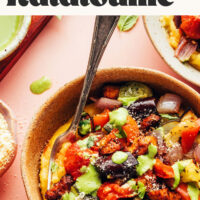 Bowl of polenta topped with veggies and tofu with text above it saying Easy Sheet Pan Ratatouille with Crispy Baked Tofu