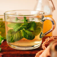 Mug of fresh mint tea with mint leaves in it