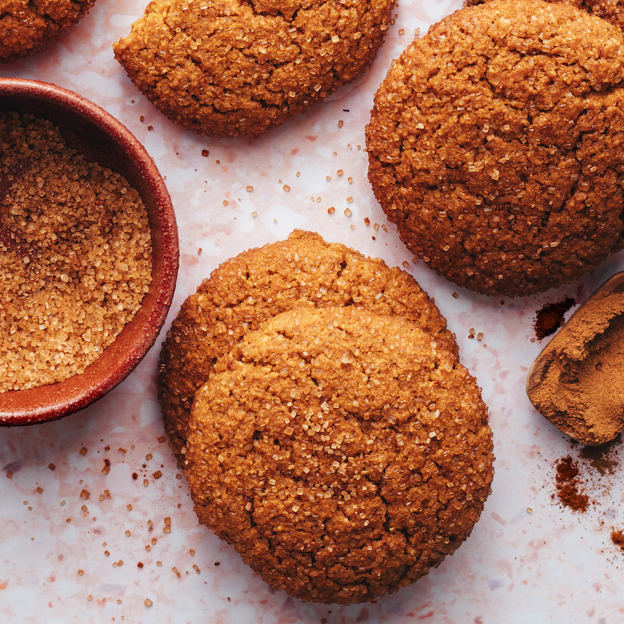 Pumpkin snickerdoodle cookies next to a bowl of sugar mixed with pumpkin pie spice