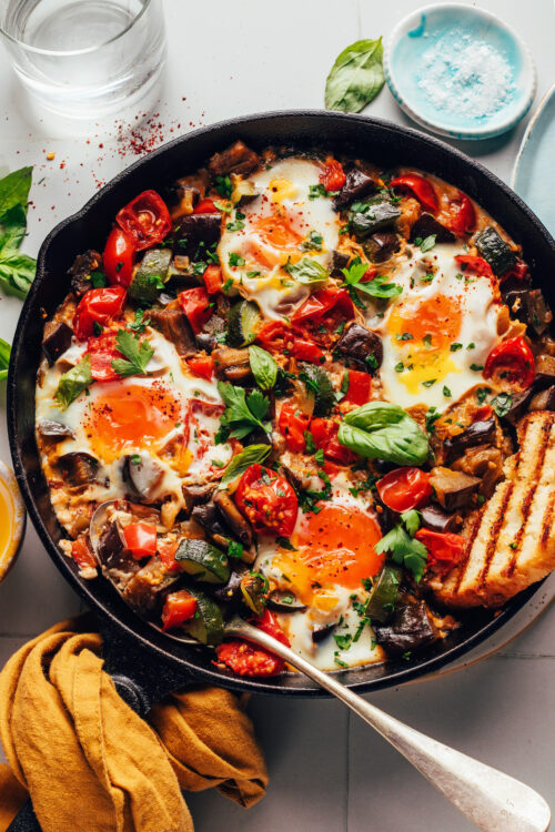 Slice of toasted bread in a pan of skillet ratatouille and eggs