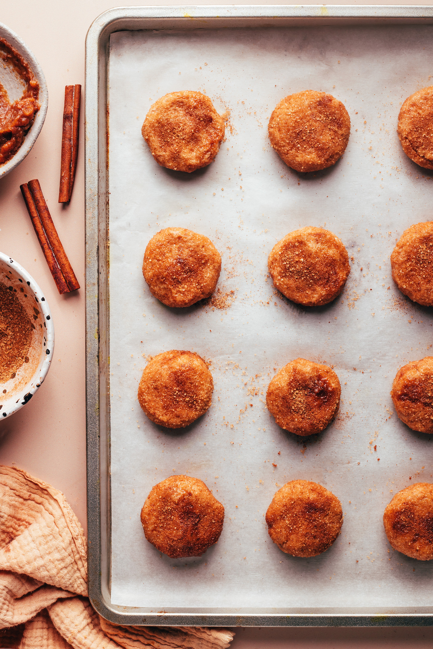 Baking sheet with circles of apple butter snickerdoodle cookie dough ready to go into the oven